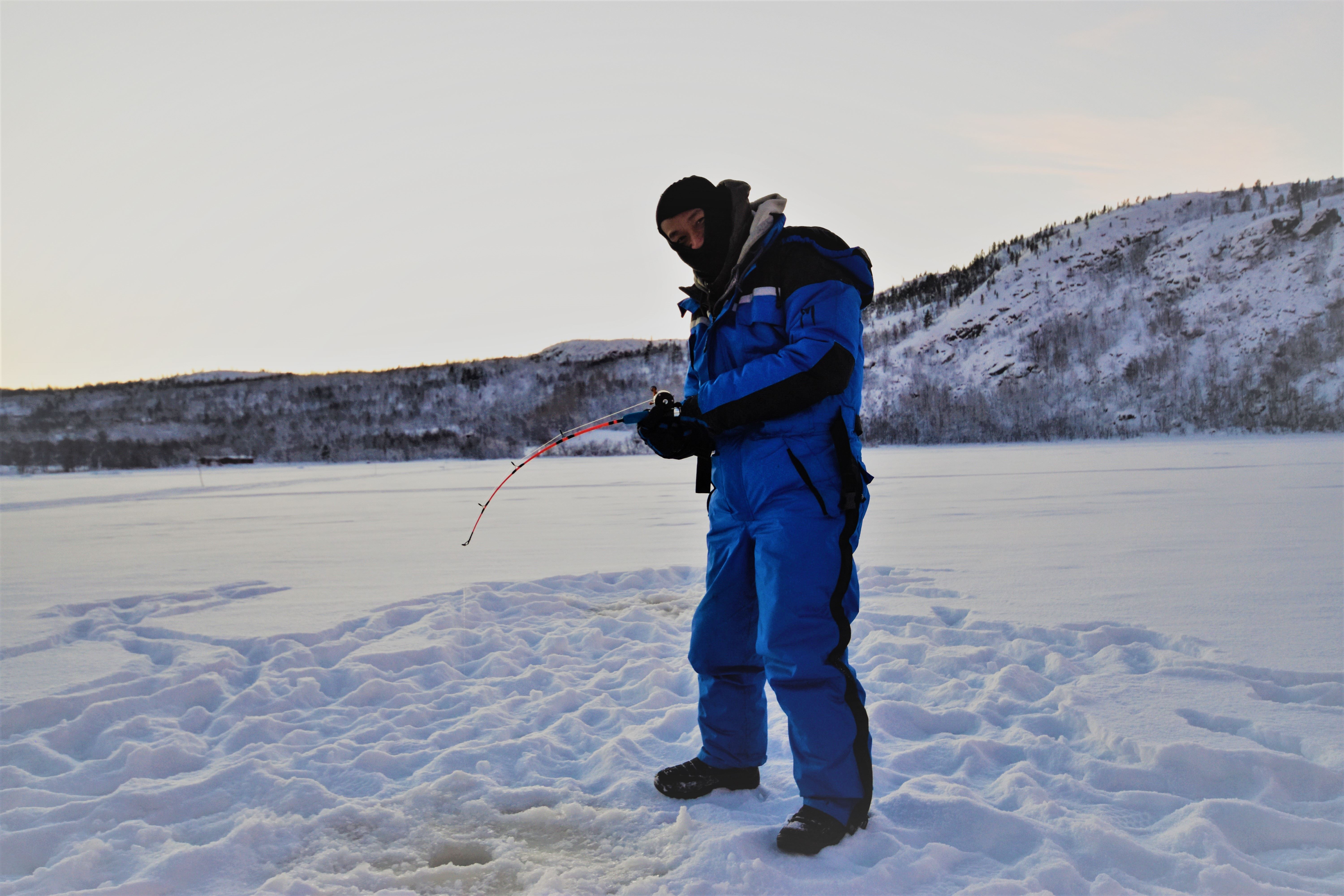 Man ice fishing in kirkenes