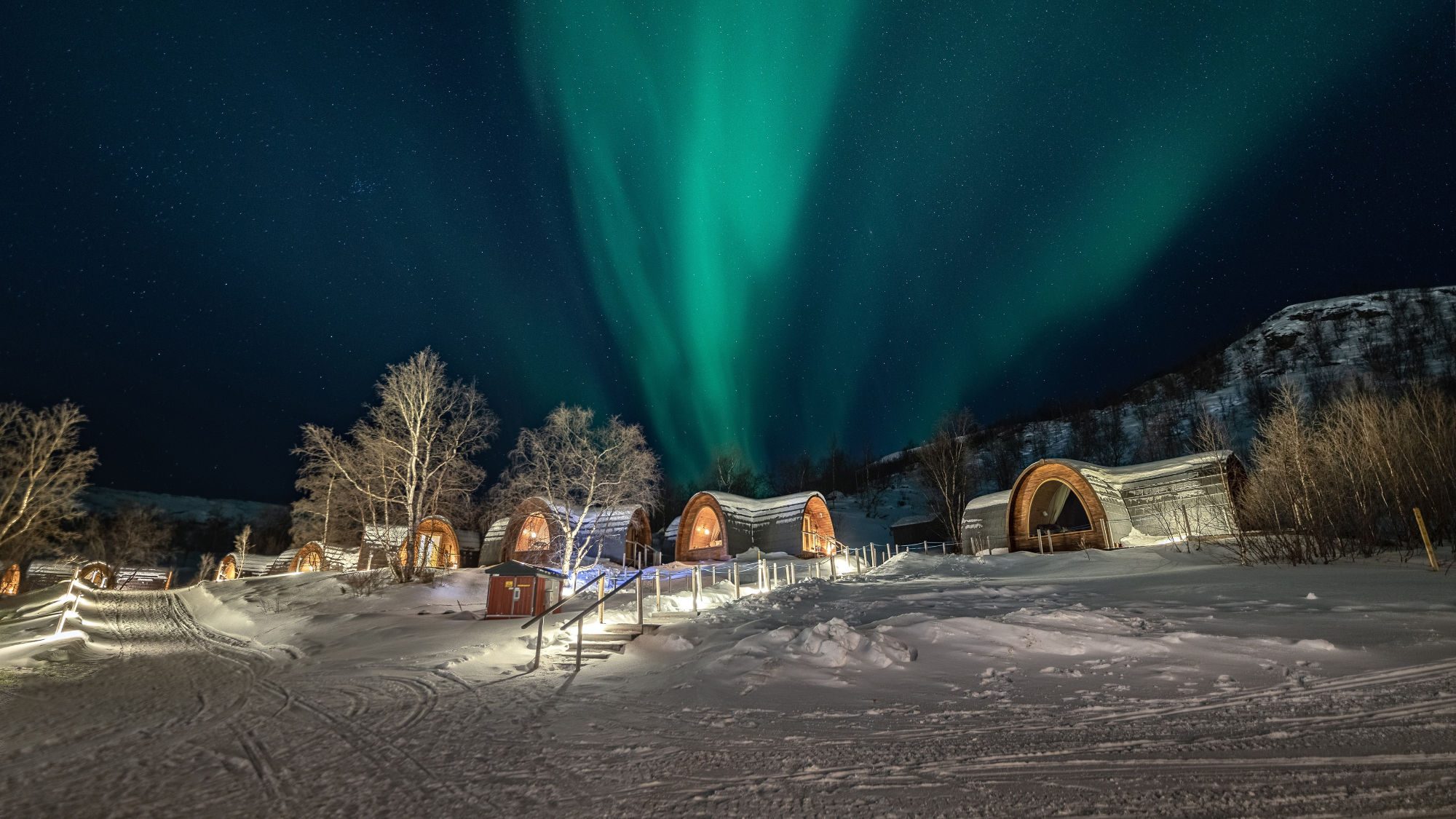 gamme huts in kirkenes norway with northern lights