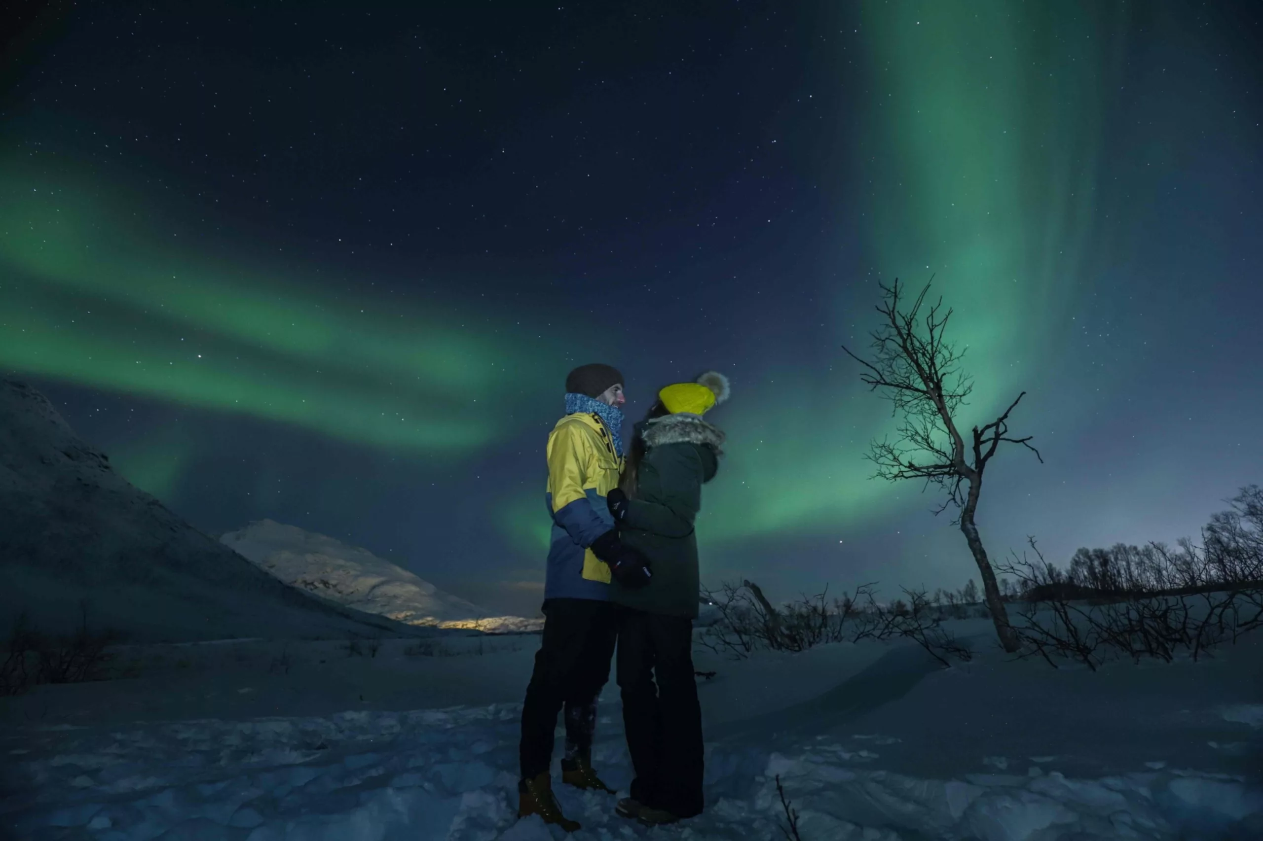 couple standing under the northern lights tromsø